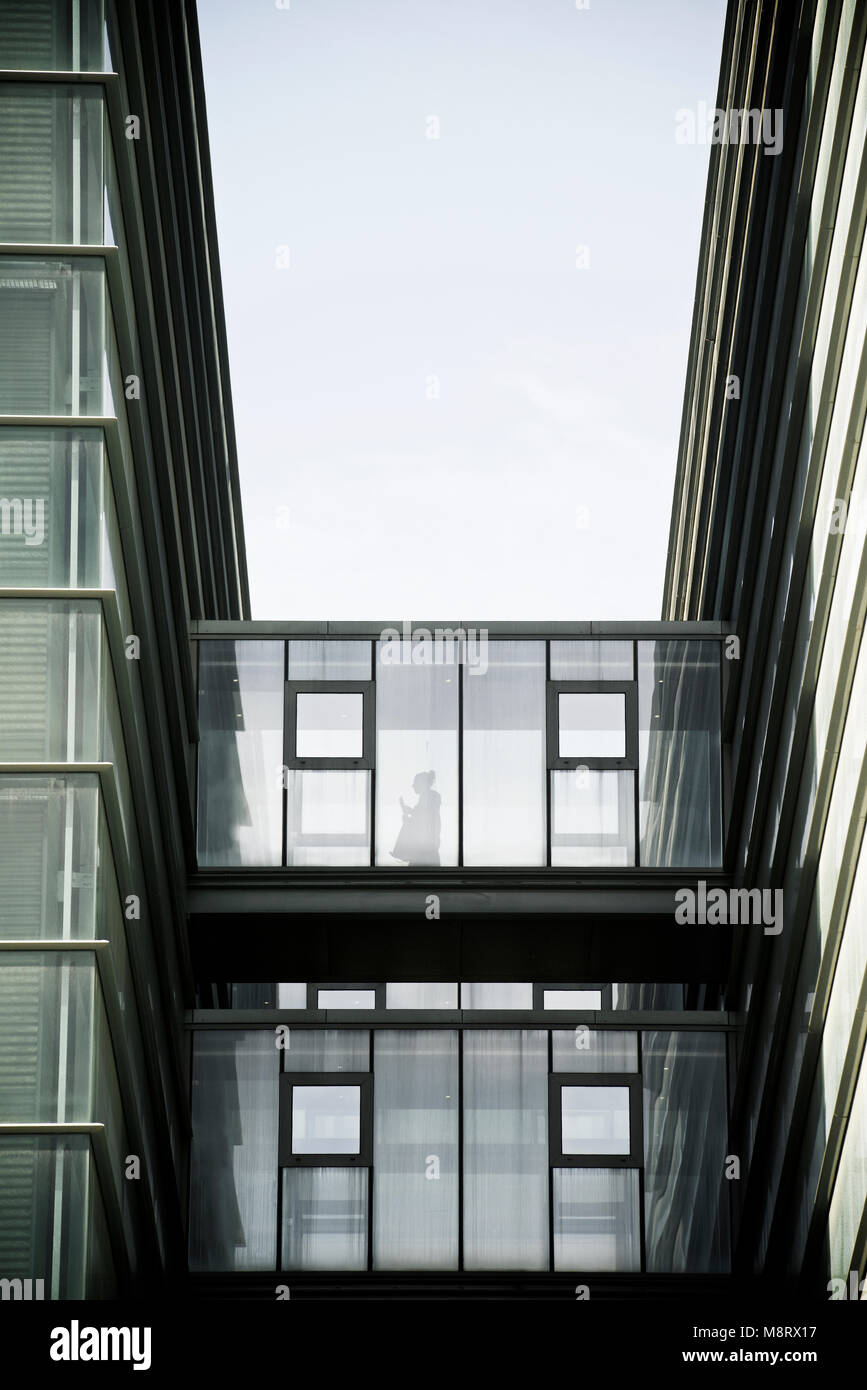 Low angle view of elevated walkway amidst buildings against sky Stock Photo