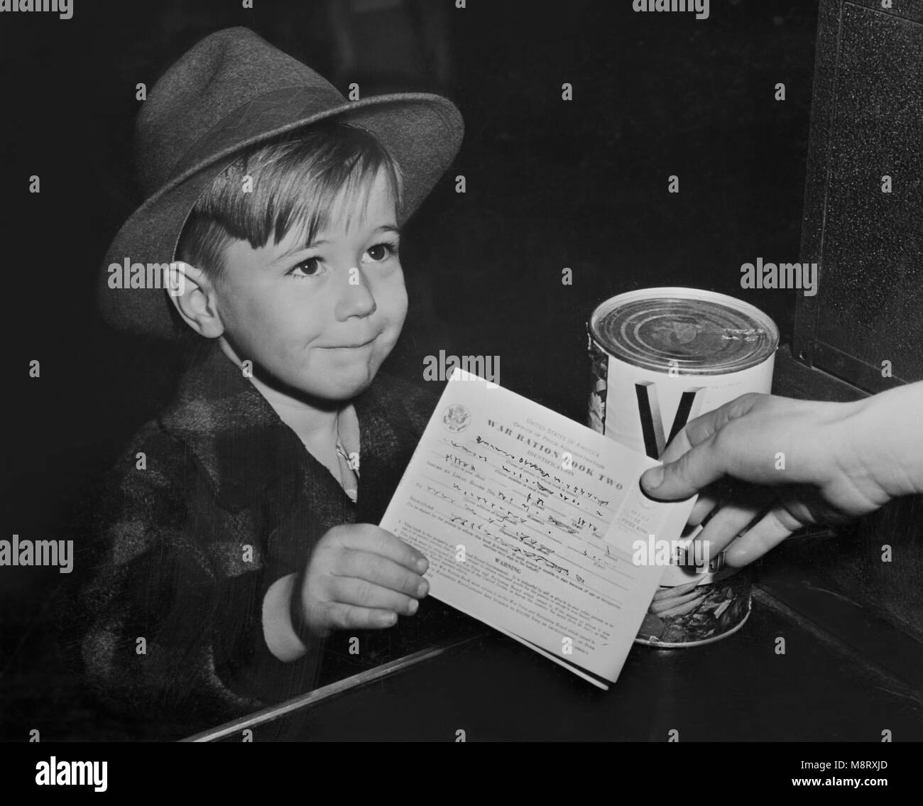 Young Boy with War Ration Book Two at Supermarket, as Children are Being Taught the Facts of Point Rationing during War, Washington DC, USA, Alfred T. Palmer for Office of War Information, February 1943 Stock Photo