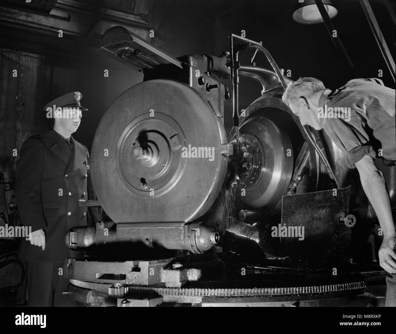 Worker Inspecting Gears of Rear Axles of Army's Half-Track Scout Car at Factory Converted to War Production, White Motor Company, Cleveland, Ohio, USA, Alfred T. Palmer for Office of War Information, December 1941 Stock Photo