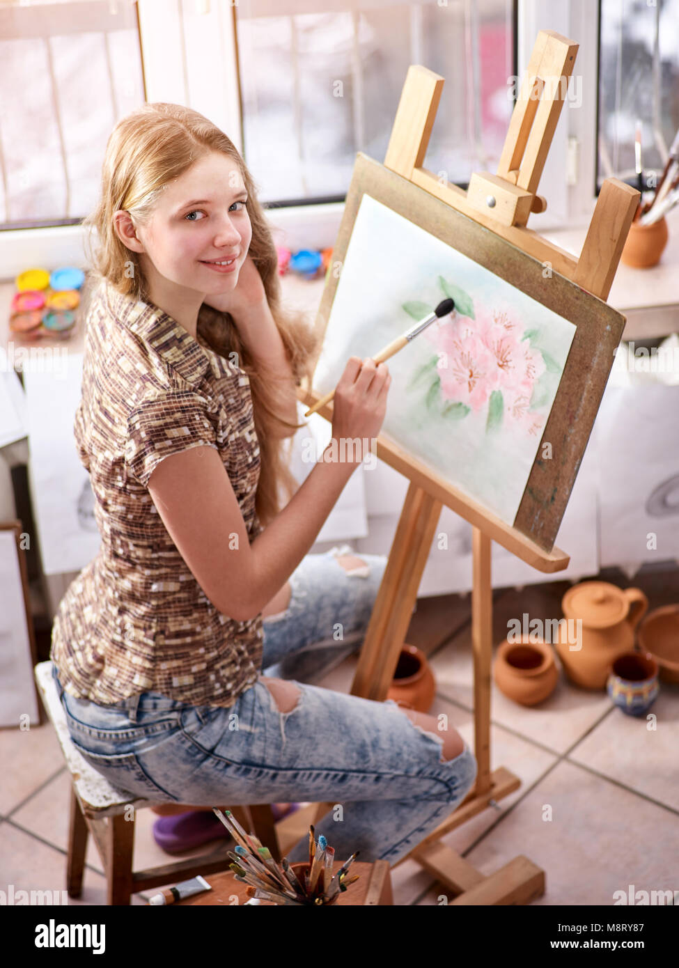 Artist painting on easel in studio. Girl paints with brush Stock Photo ...
