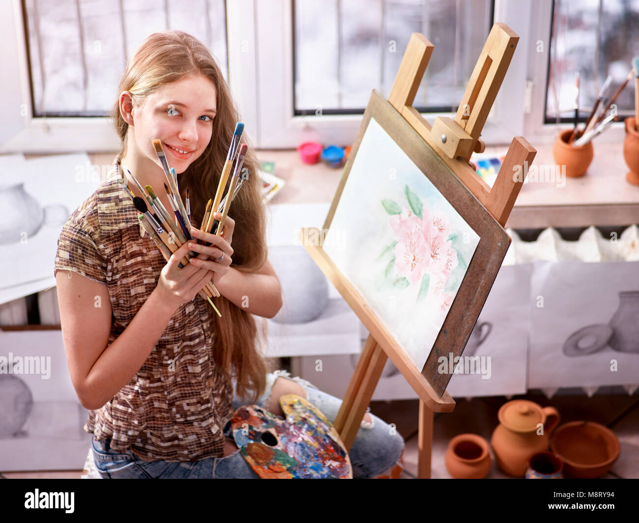 Artist painting on easel in studio. Girl paints with brush Stock Photo ...