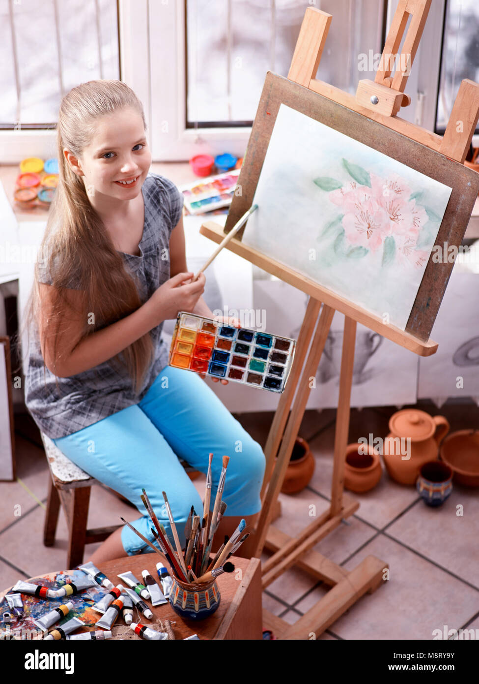 Artist painting on easel in studio. Girl paints with brush Stock Photo ...