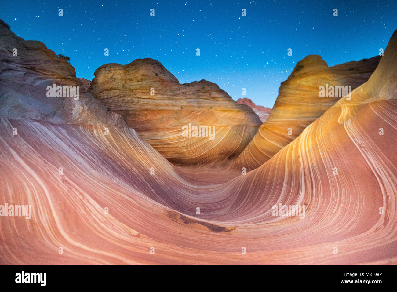 A shooting star passes over the Wave sandstone rock formation, located in Coyote Buttes North, Paria Canyon, Vermillion Cliffs Wilderness. Stock Photo