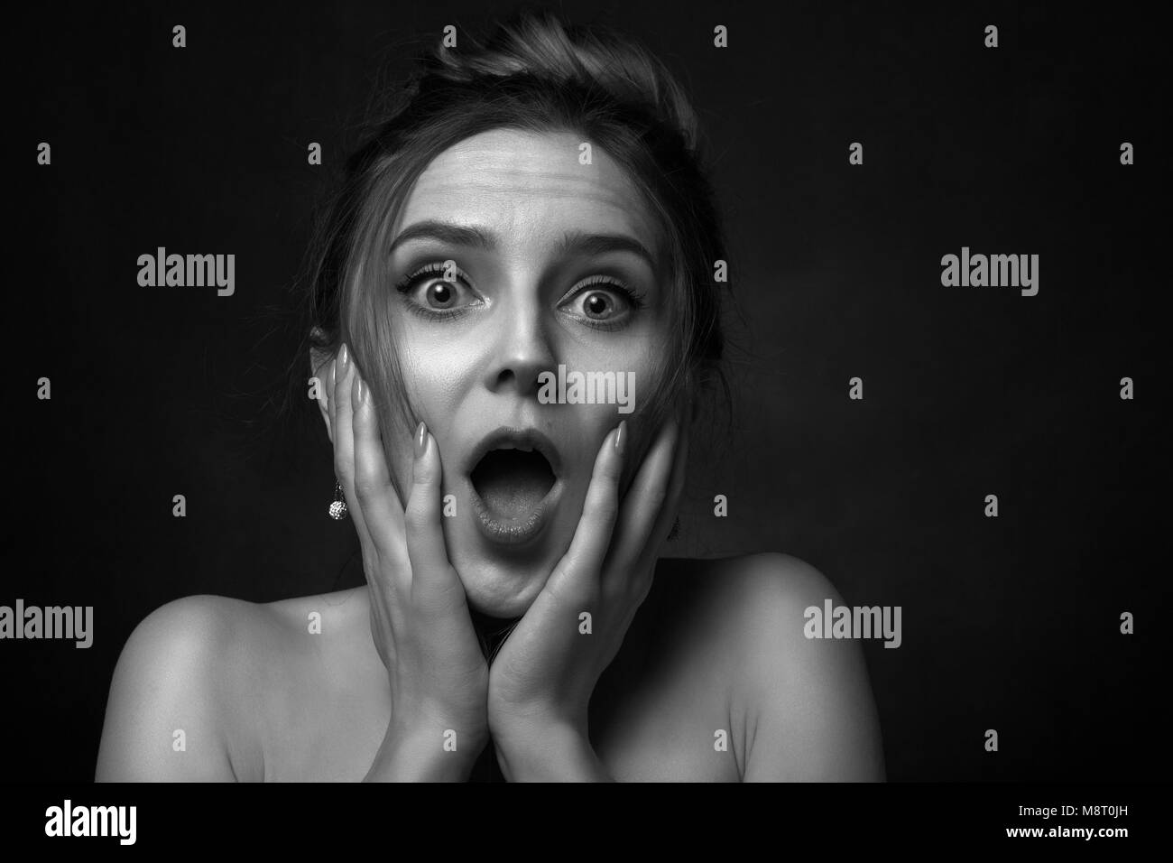 fun stressed scared girl in dark looking at camera screaming, monochrome Stock Photo