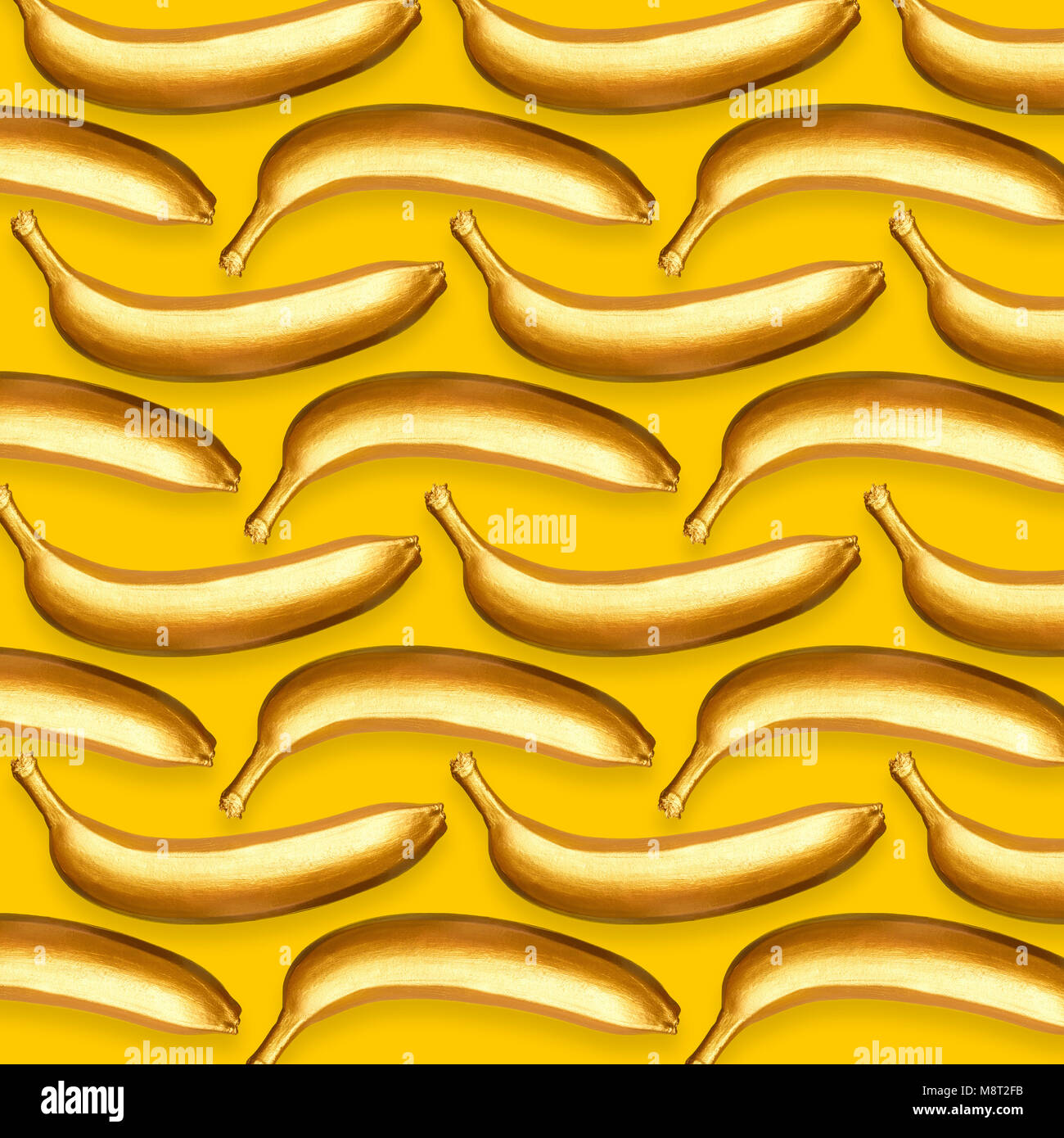 Pattern of golden bananas on a yellow background Stock Photo