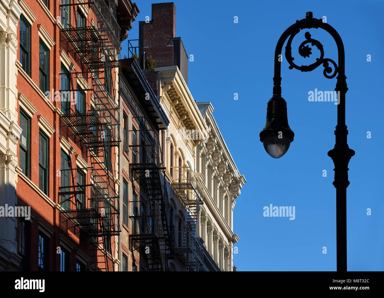 Soho building facades with cornices, fire escapes and a lamp-post. Manhattan, Soho, New York City Stock Photo