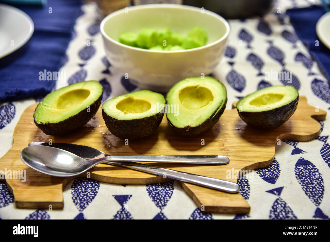 https://c8.alamy.com/comp/M8T4NP/4-halved-avocados-sit-on-a-cute-cow-shaped-wooden-cutting-board-a-M8T4NP.jpg