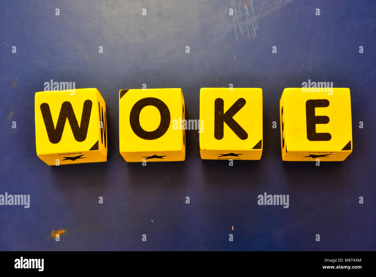 yellow block letters spelling the slang word 'woke.' Stock Photo