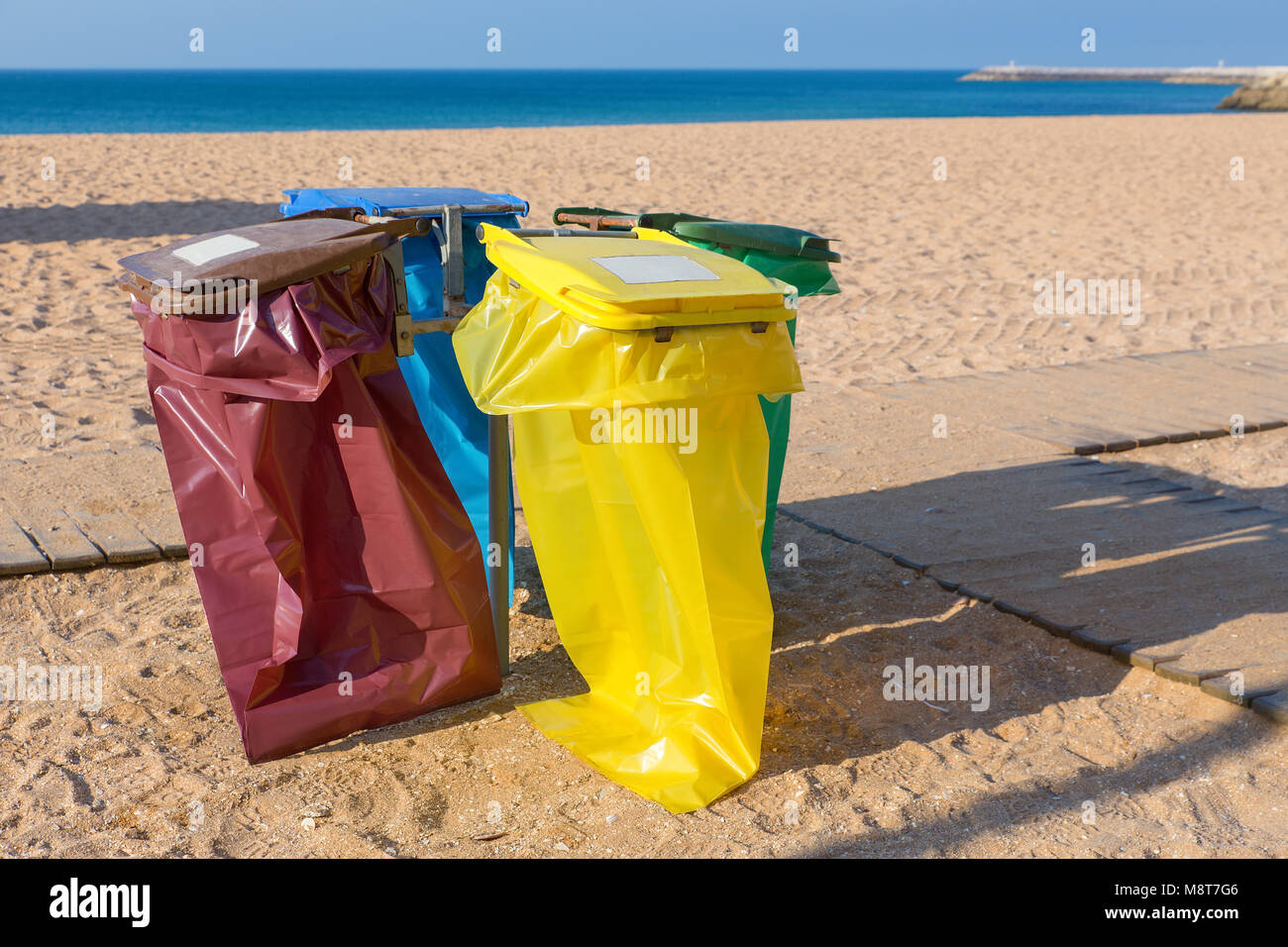 Empty garbage bags on portuguese beach at sandy coast Stock Photo
