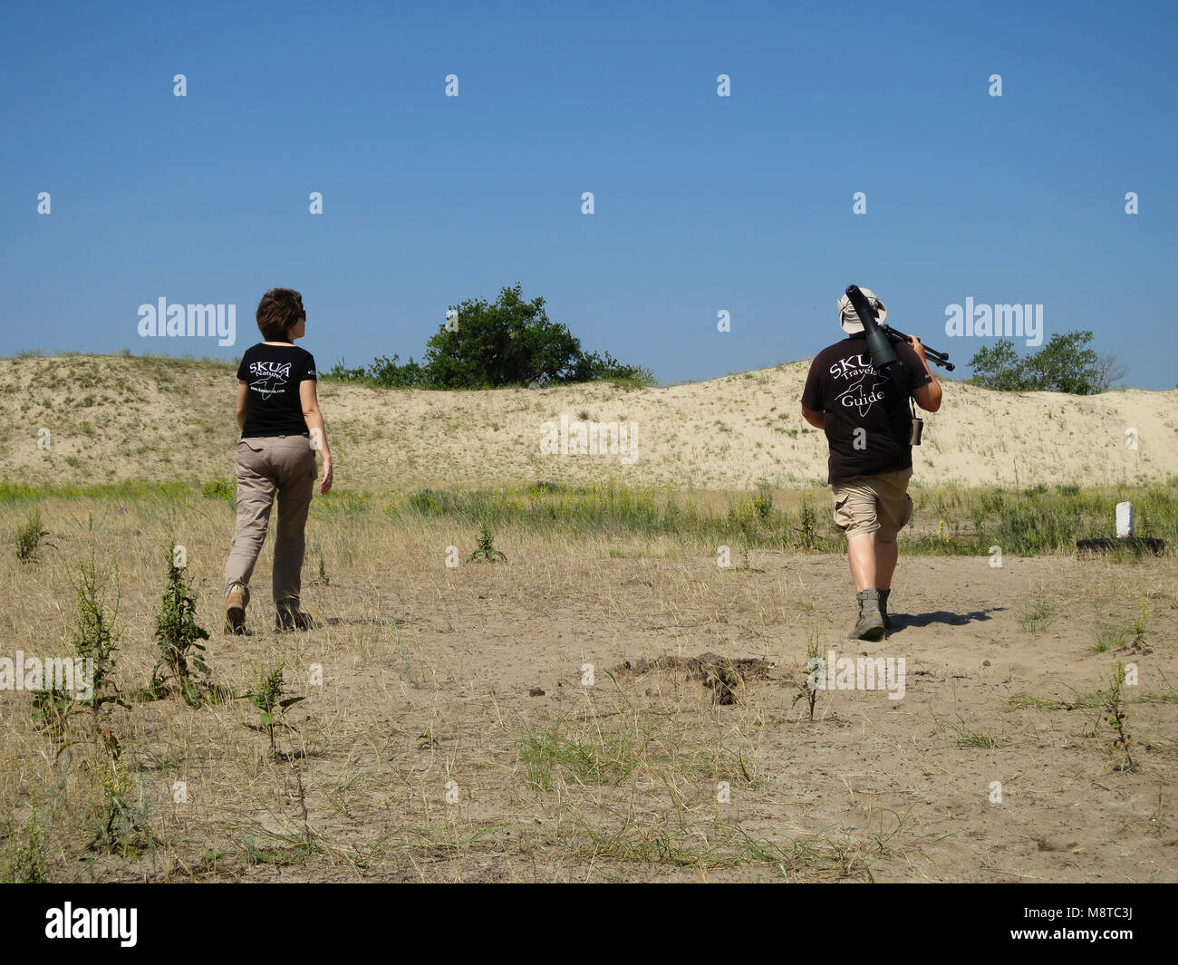 Vogelaars wandelend door natuurgebied; Birdwatchers hiking in nature area Stock Photo