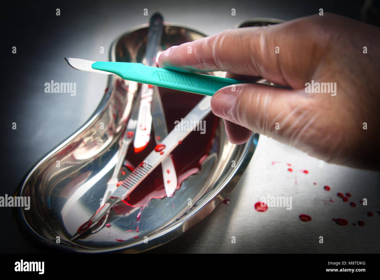 Montreal,Canada 18,March 2018.Gloved hand holding a surgical scalpel in an ER setting.Credit:Mario Beauregard/Alamy Live New Stock Photo