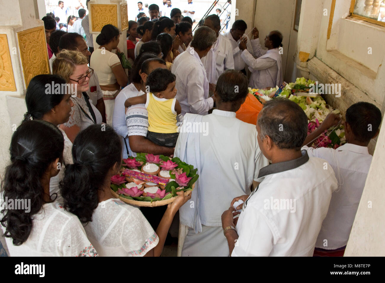 Local people and pilgrims praying and giving flower gifts at the Jaya Sri Maha Bodhi temple in Anuradhapura, Sri Lanka. Stock Photo