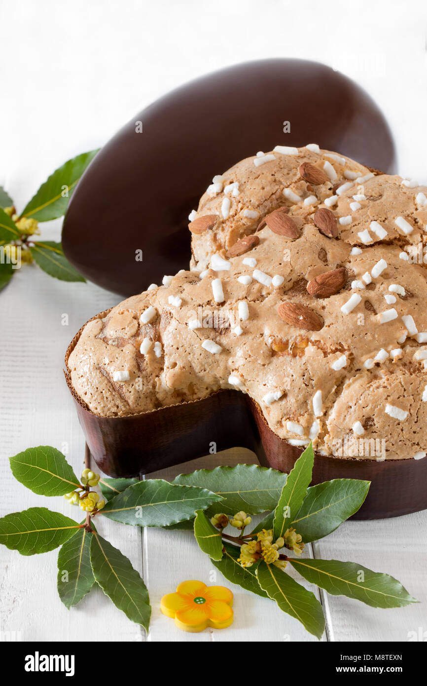 Colomba pasquale, typical italian sweet for Easter and chocolate egg on white wooden background. Stock Photo