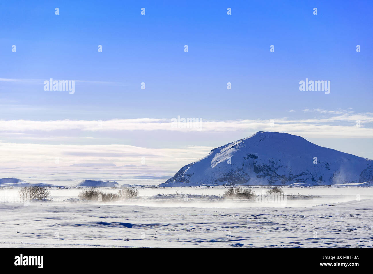Myvatn geothermal lake and Mount Vindbelgjarfjall, northern Iceland. Snowy winter scene, steaming lake with mountain background Stock Photo