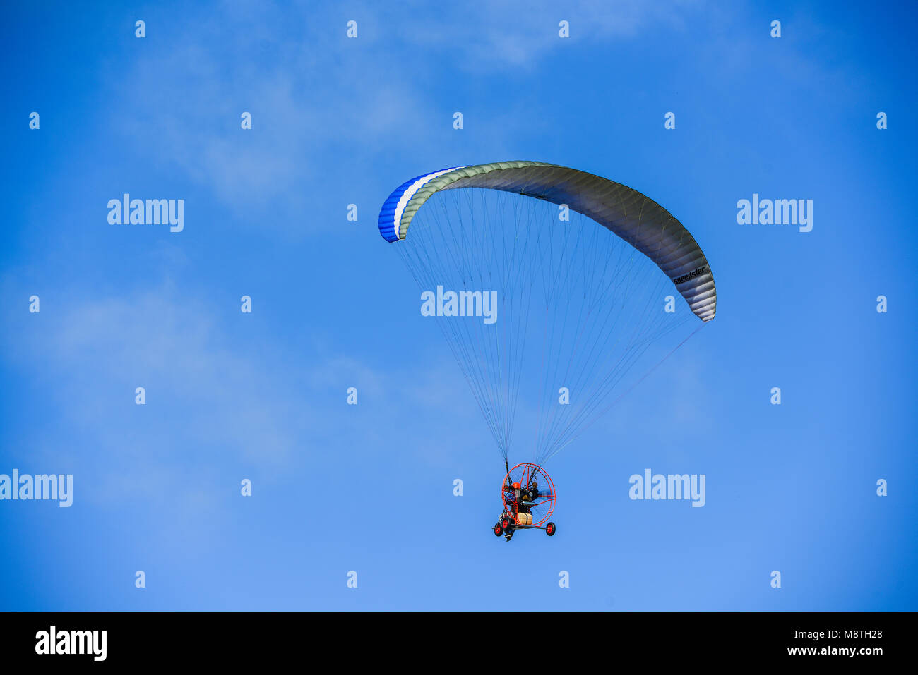 Un-identified man flying with glider in the clear sky day Stock Photo