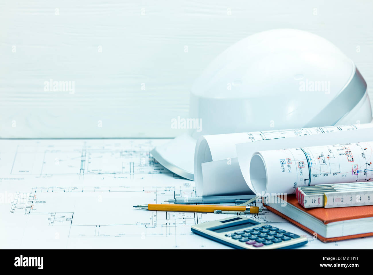 contractors workplace background. drawing and measuring tools, protective helmet, notebook, blueprints. construction concept. Stock Photo