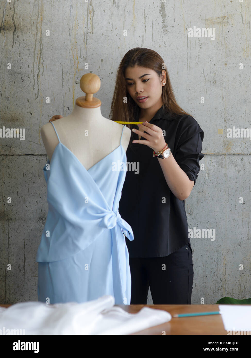 Asian female clothing designer using dress dummy, freelance lifestyle. Stock Photo