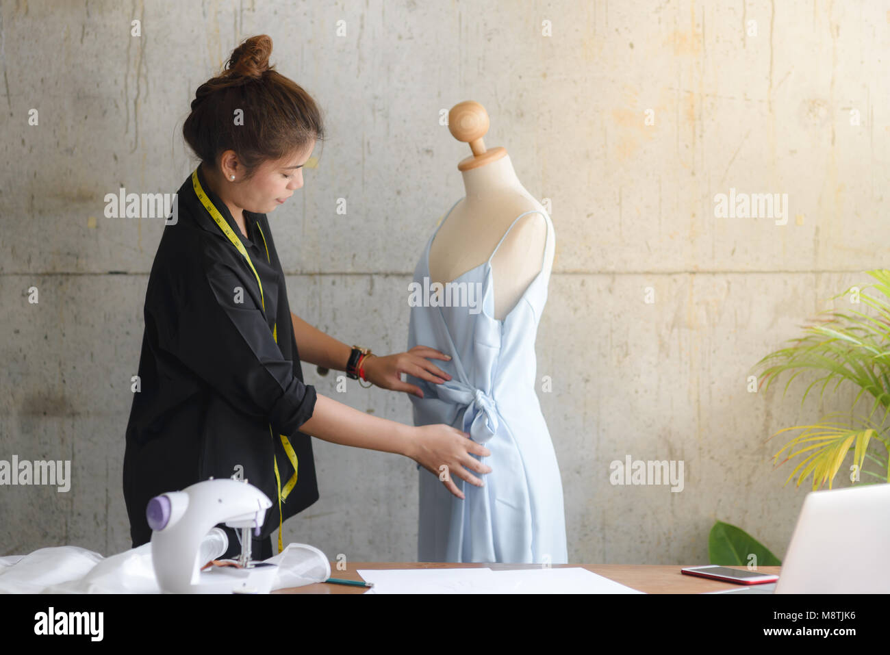 Asian female clothing designer using dress dummy, freelance lifestyle.  Selective focus. Stock Photo