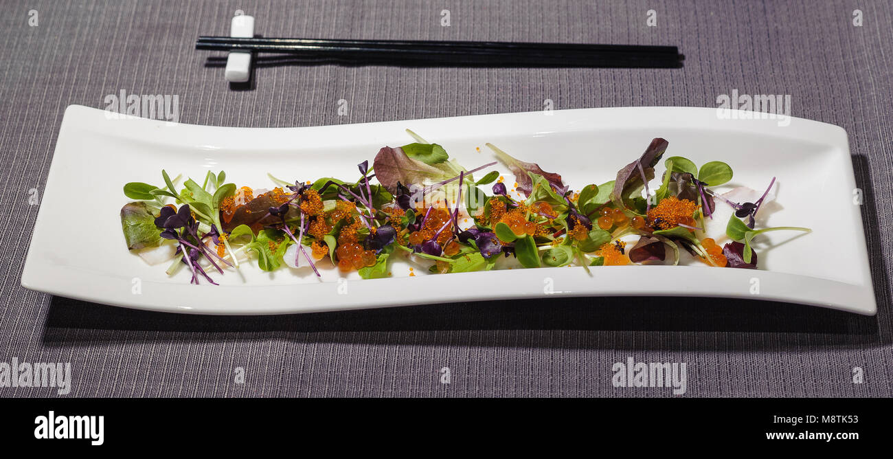 octopus carpaccio with small leaves salad and different types of caviar, fresh and raw food Stock Photo