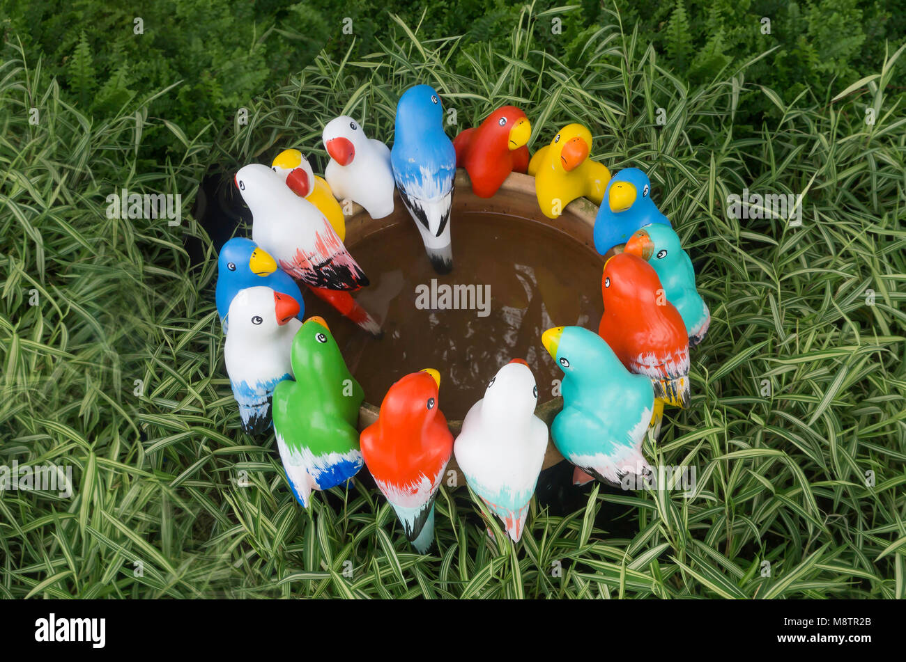 Group of colorful bird statue are meeting in garden Stock Photo