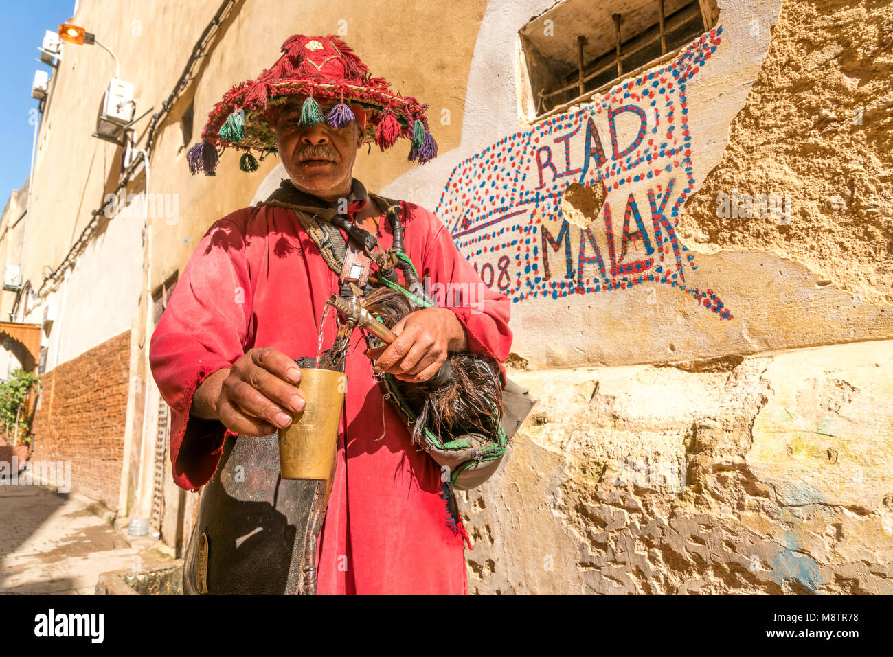 traditioneller Wasserverkäufer in der Medina von Fes, Königreich Marokko, Afrika  | traditional  water seller in the medina, Fes, Kingdom of Morocco,  Stock Photo