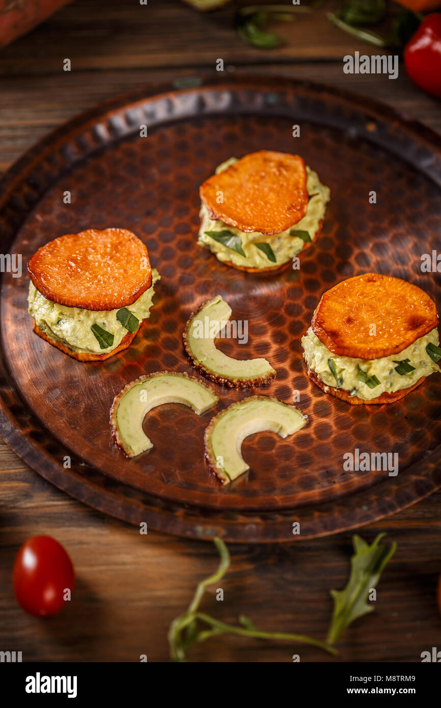 Sweet potato bruschettas with avocado cream, healthy vegetarian food Stock Photo