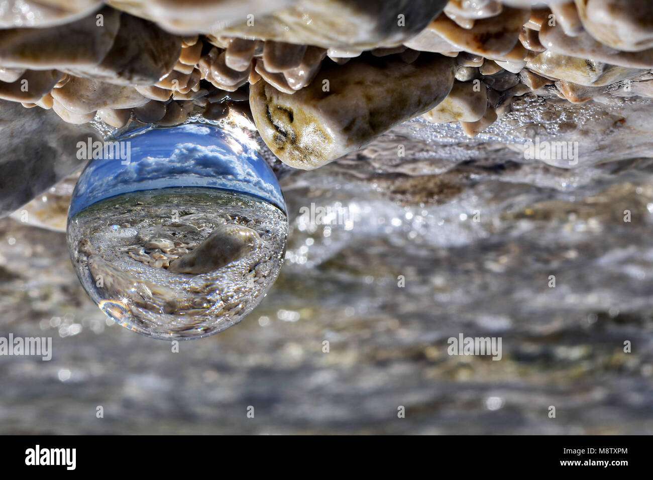 Reflection of the sea in crystal ball at the beach Stock Photo