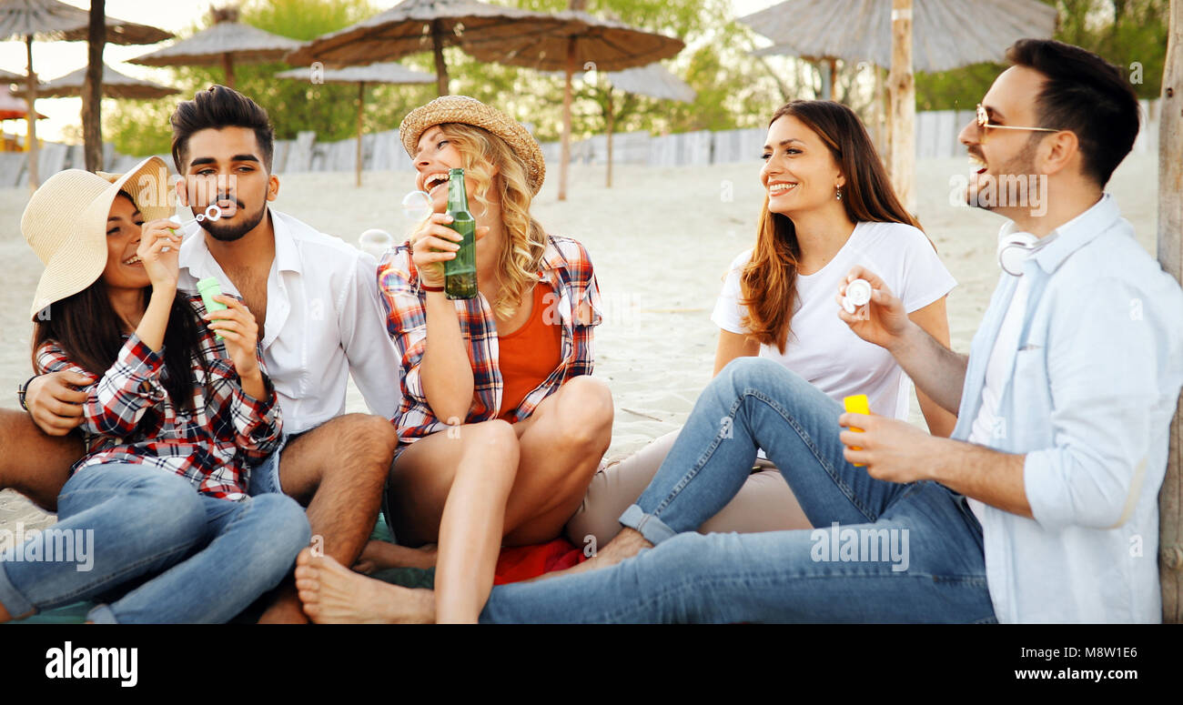 Beach party with friends. Cheerful young people spending nice time together on the beach Stock Photo