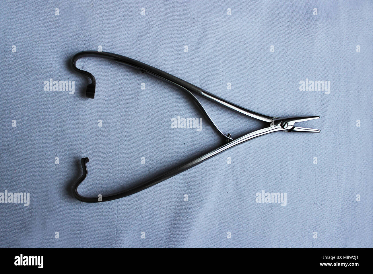 Medical instrument one needle holder lies on a blue cloth Stock Photo