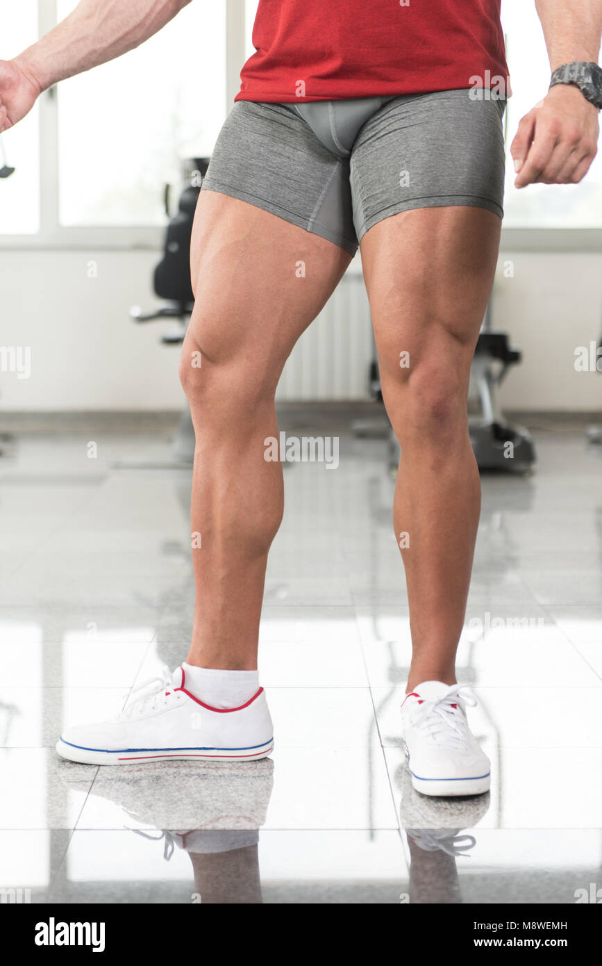 Healthy Young Man Standing Strong In The Gym And Flexing Legs close Up -  Muscular Athletic Bodybuilder Fitness Model Posing After Exercises Stock  Photo - Alamy