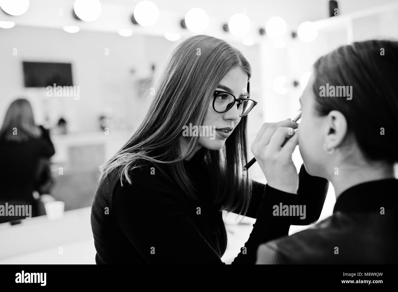 Make up artist work in her beauty visage studio salon. Woman applying