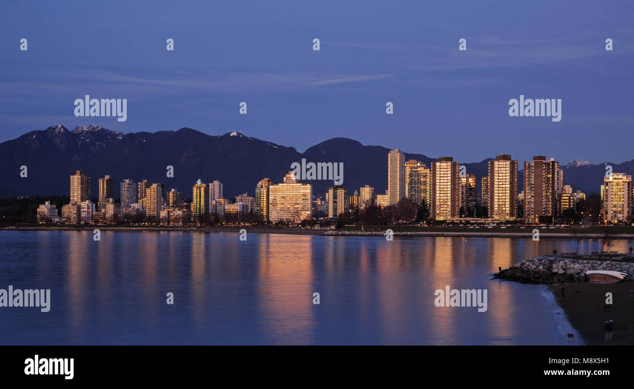 Vancouver, British Columbia, Canada. 5th Jan, 2014. A colorful sunset is reflected in English Bay by the high-rise buildings of Vancouver's West End district. The North Shore Mountains are seen in the background. Credit: Bayne Stanley/ZUMA Wire/Alamy Live News Stock Photo