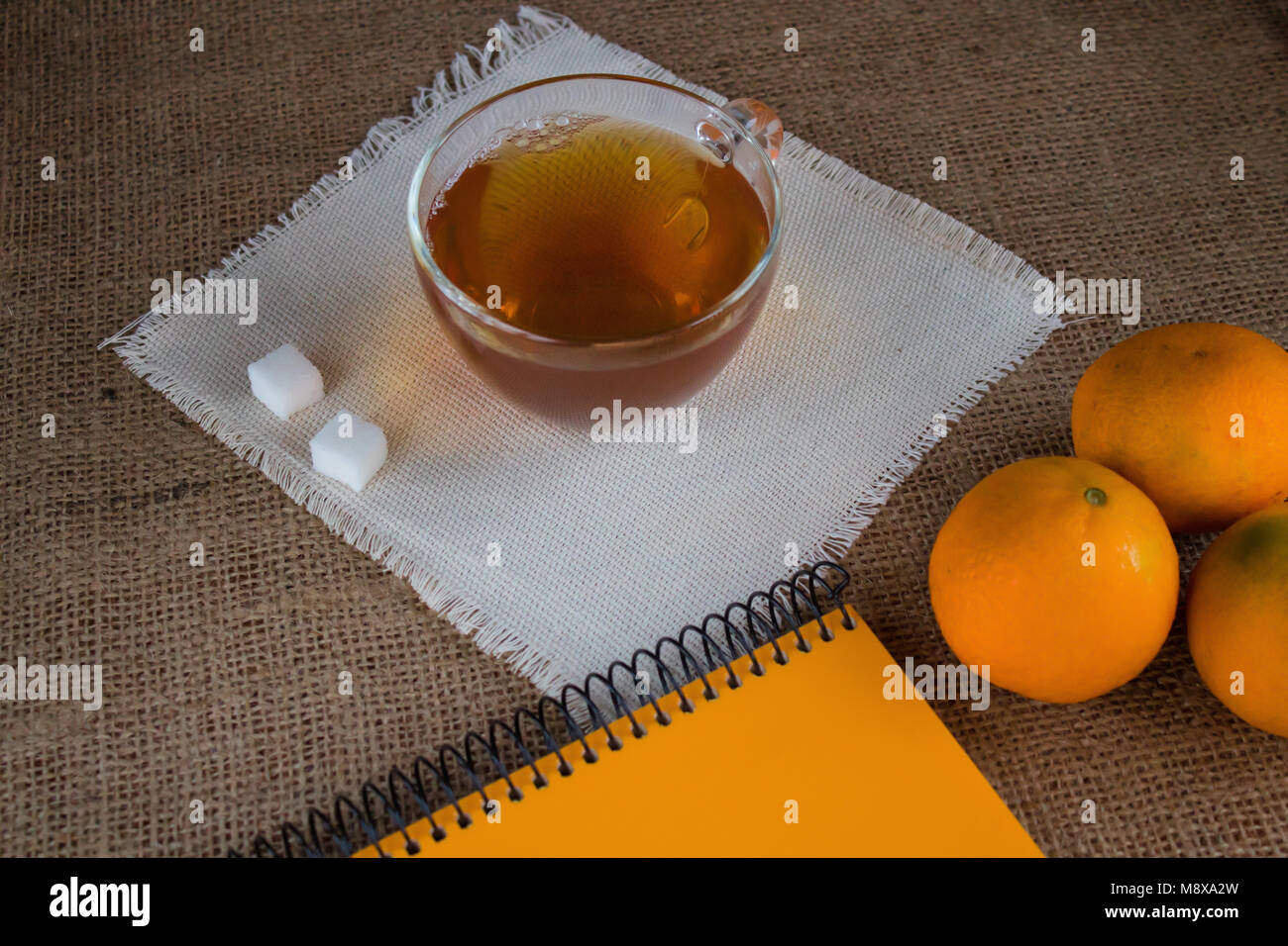 Morning cup of tea. Mandarins on the table. Notepad to write plans for the day. Stock Photo