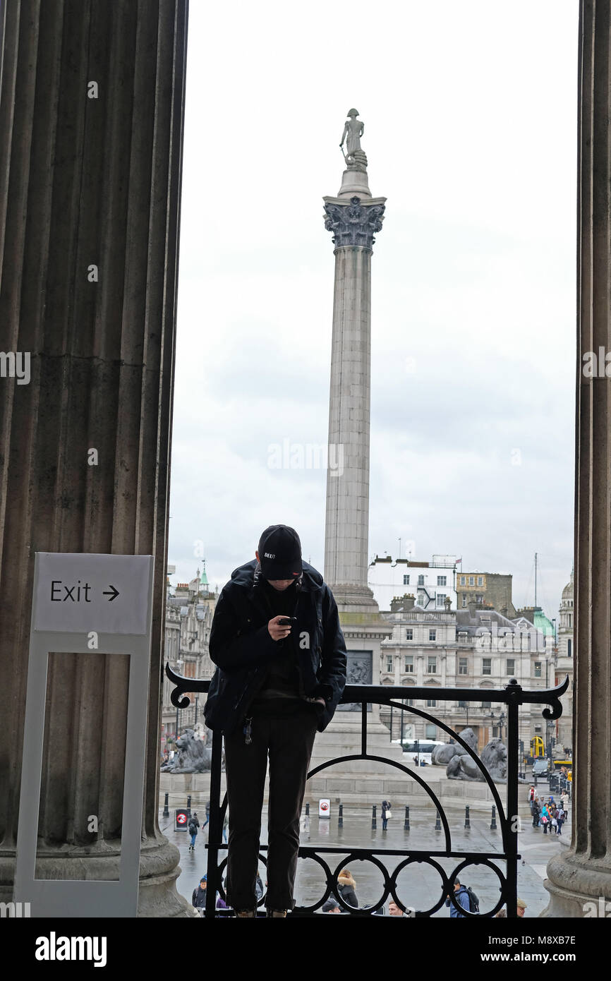 A tourist on his phone with Nelsons column in the background. Stock Photo