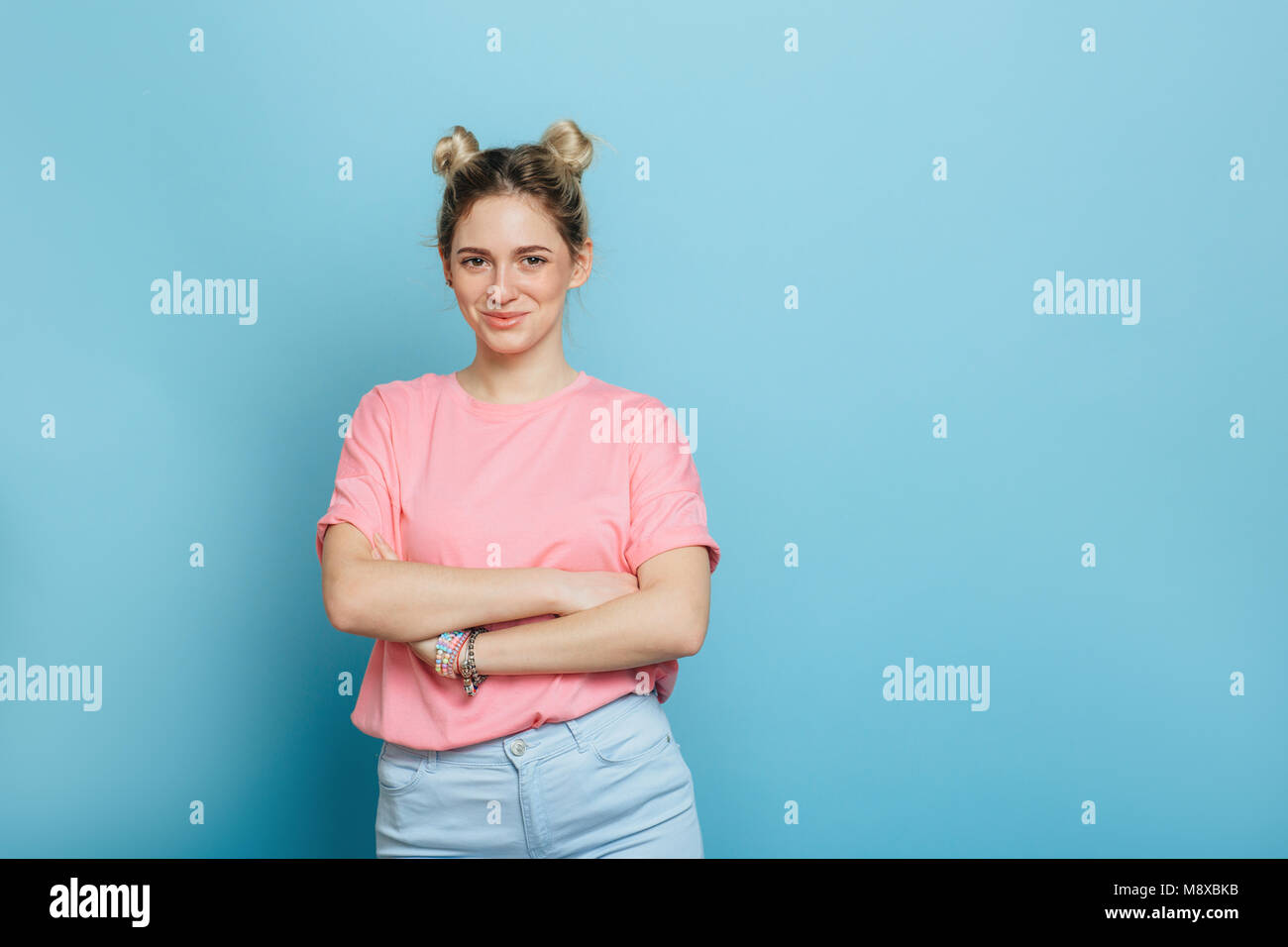 young woman in a pink t-shirt on a blue background Stock Photo