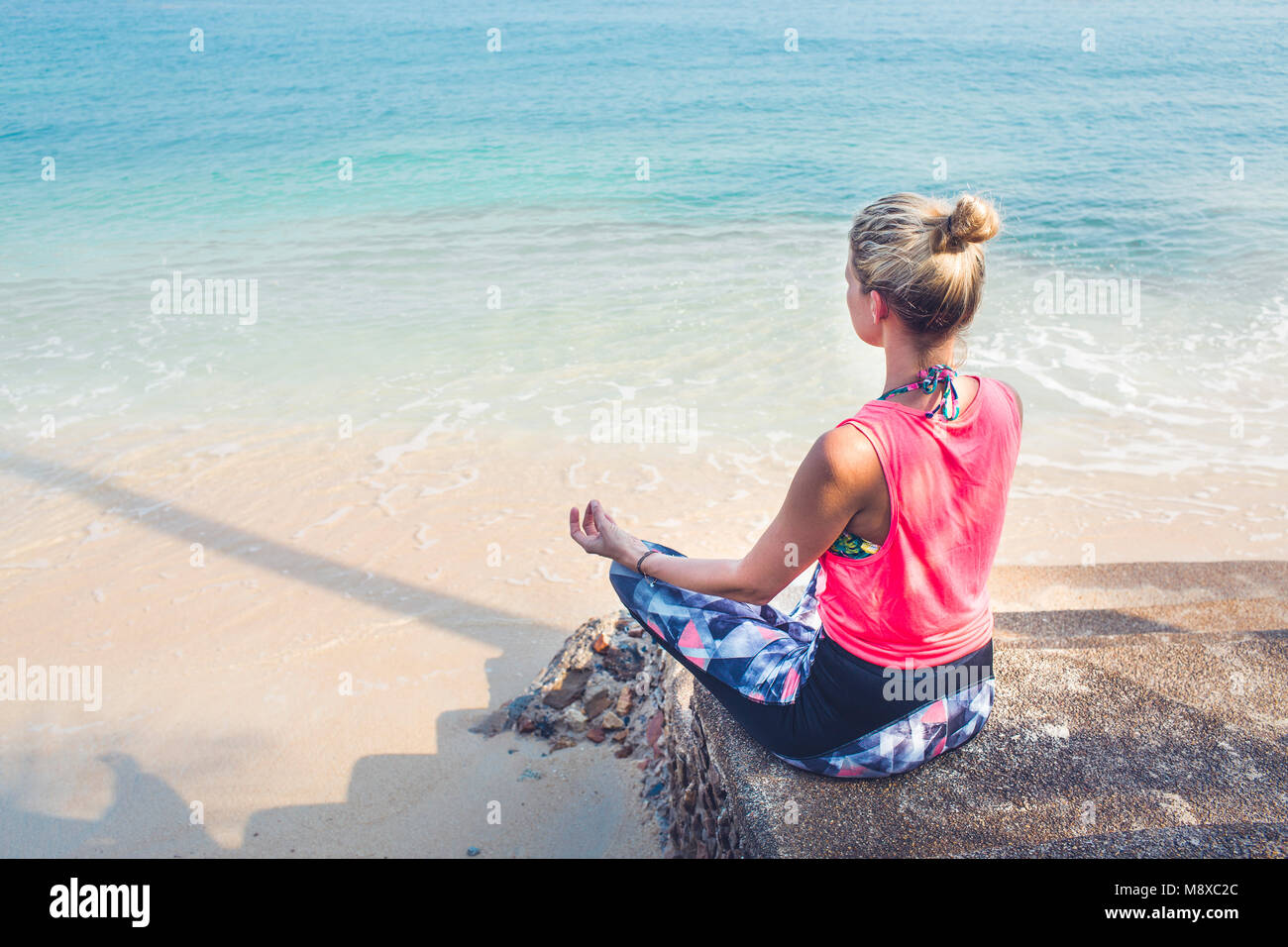 Caucasian woman meditating in a yoga pose on beach Stock Photo - Alamy