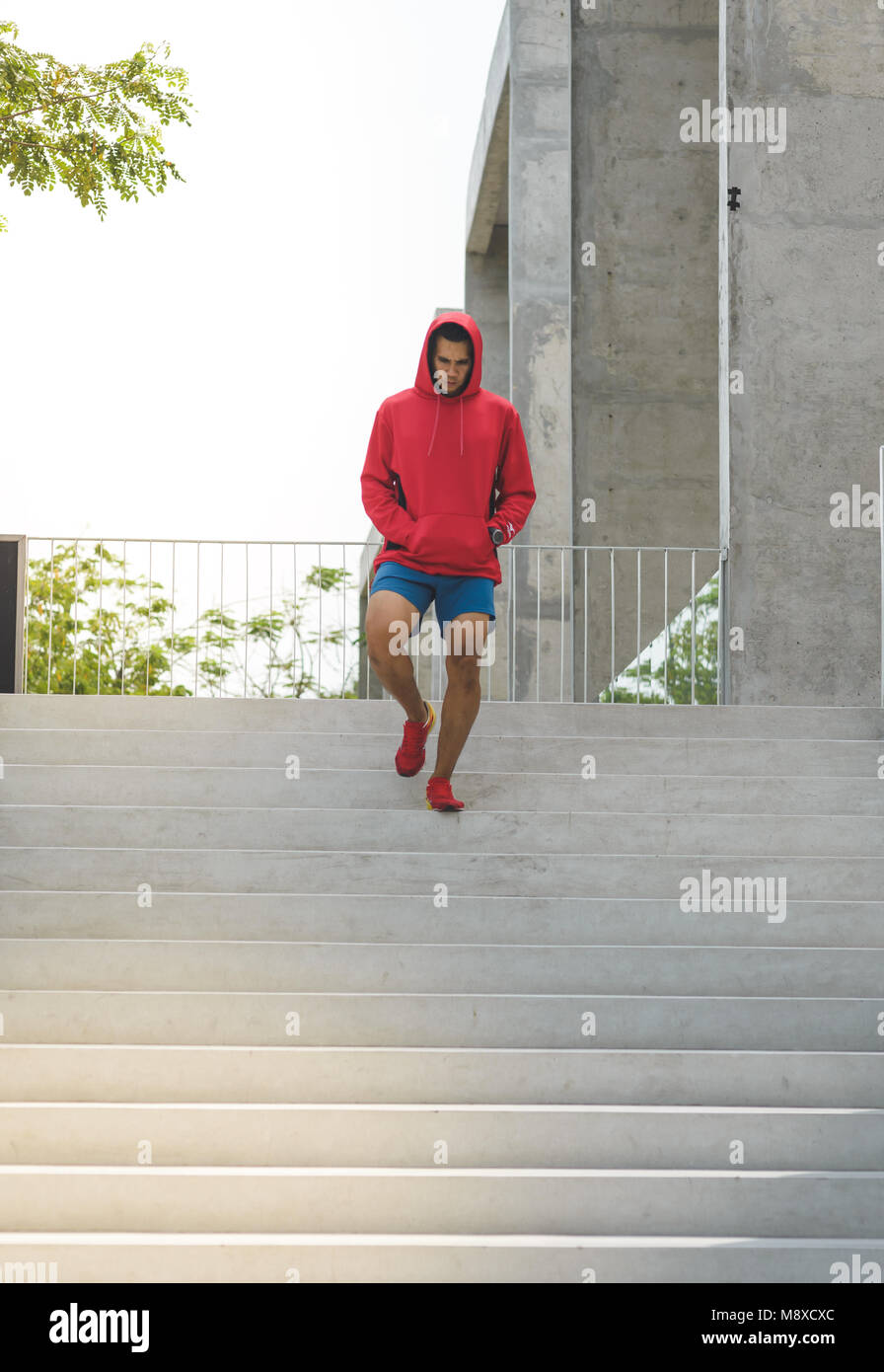 Urban athlete running upstairs. Sporty man working out outside and