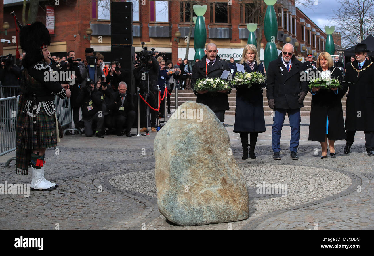 Wendy Parry (fourth right) and her husband Colin (third right) lay flowers at the memorial stone on Bridge Street, in Warrington, where two IRA bombs were detonated, killing their son Tim Parry, 12, and Johnathan Ball, three, and injuring over fifty others, during the 25th anniversary service of the Warrington bombing attack. Stock Photo