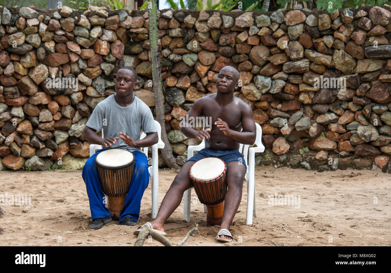 african man playing on the the bongo drums, the traditional way of music, they perform also for tourists in the lodges Stock Photo