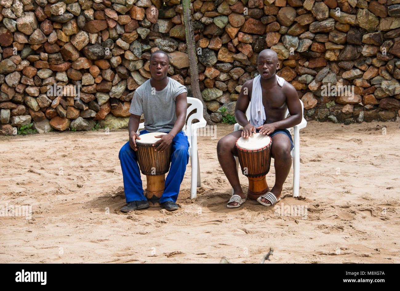african man playing on the the bongo drums, the traditional way of music, they perform also for tourists in the lodges Stock Photo