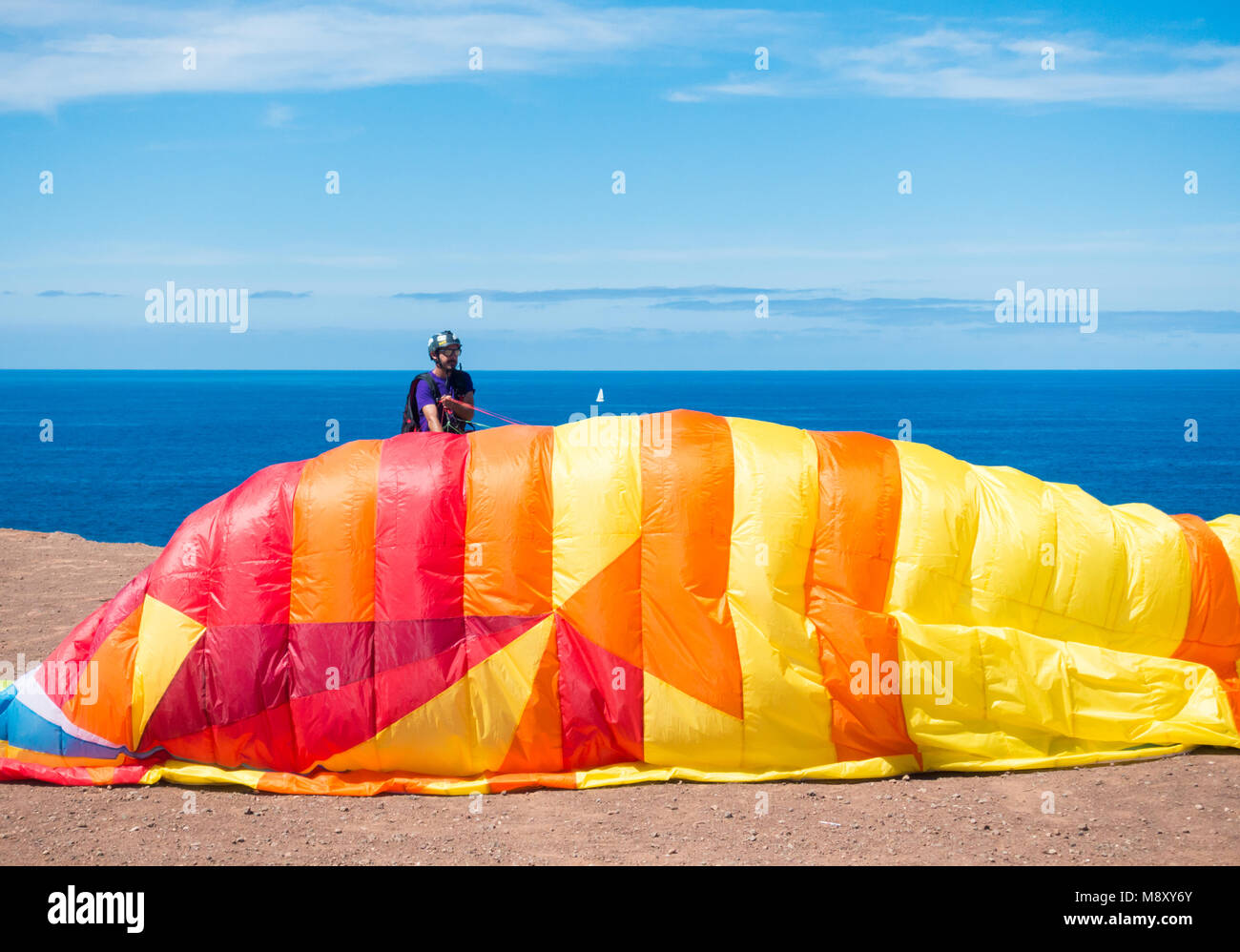 Paraglider launching from cliff overlooking Atlantic Ocean in the Canary Islands, Spain Stock Photo