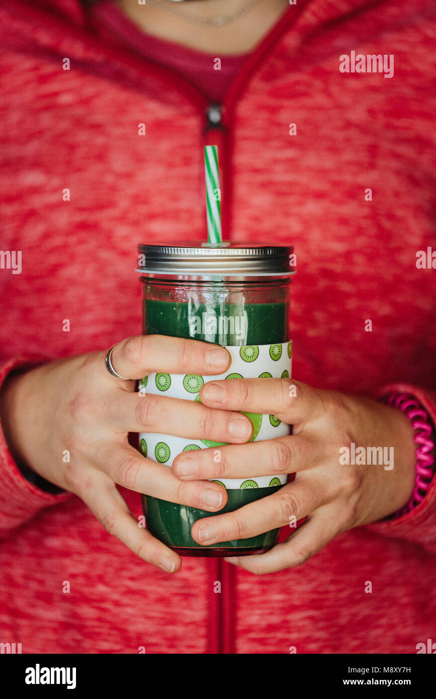 Womans hands holding a green Detox juice Stock Photo