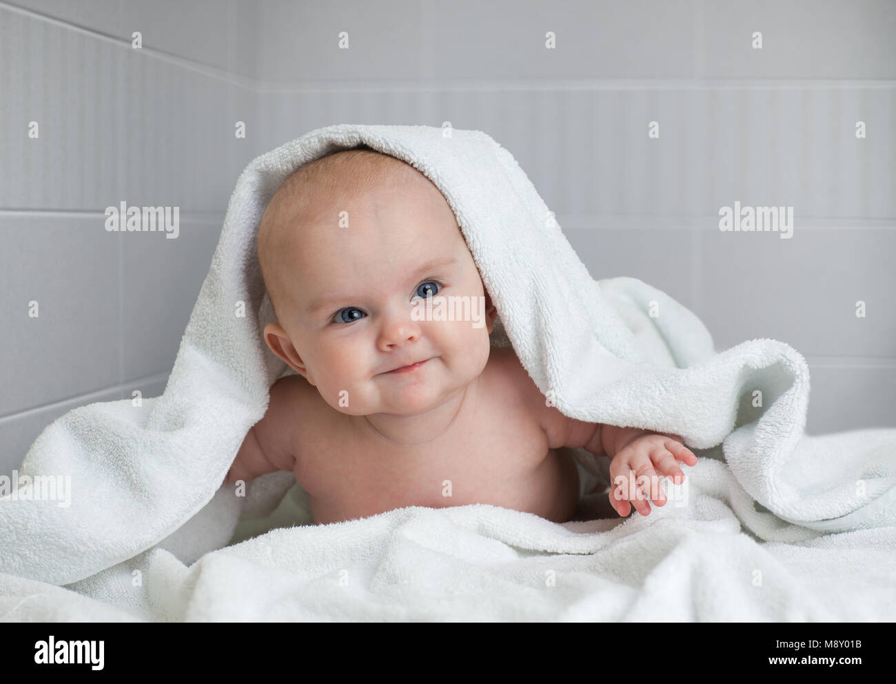 cute baby in white bathing towel in bathroom Stock Photo Alamy