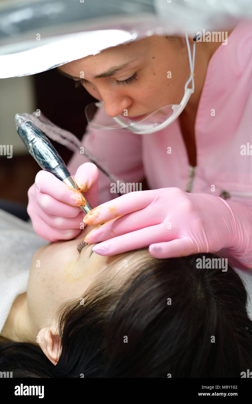 The doctor does cosmetic procedures on the girl's face Stock Photo