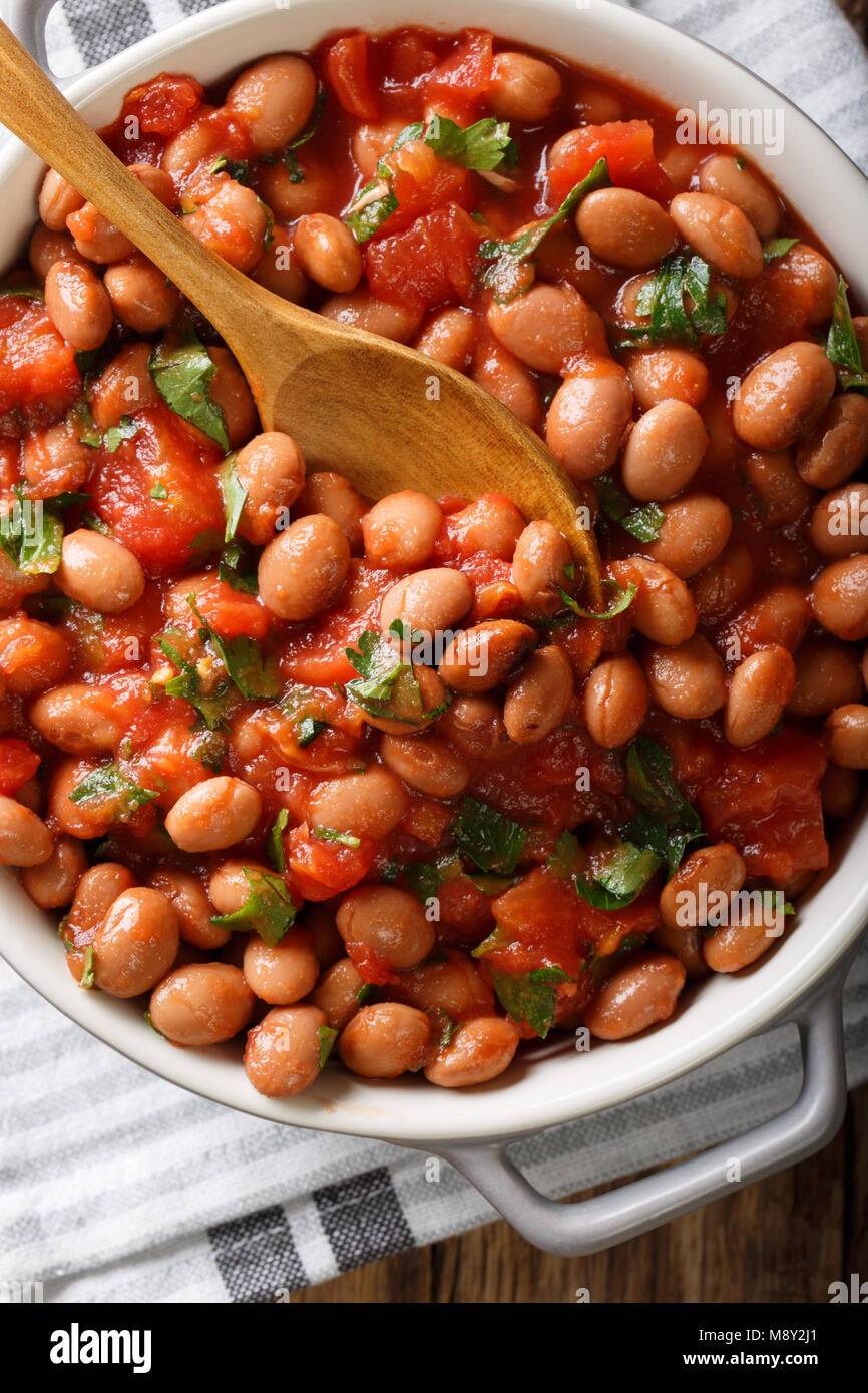 Cranberry beans in tomato sauce with herbs closeup in a bowl on the