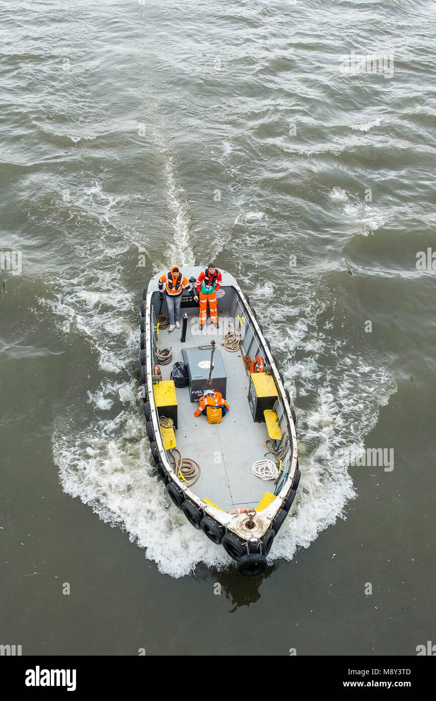 An overhead view of a small boat steaming upriver on the River Thames in London. Stock Photo
