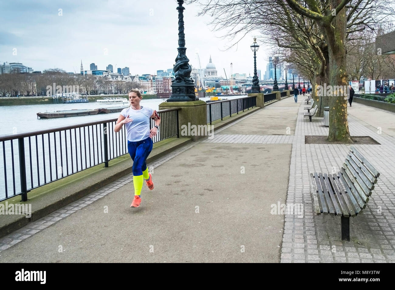 A woman running along the Embankment in London. Stock Photo