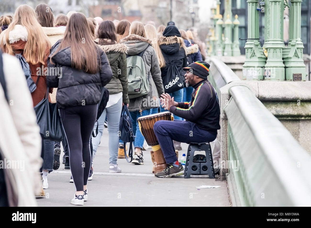 A street entertainer drumming on a Djembe on Westminster Bridge in London. Stock Photo