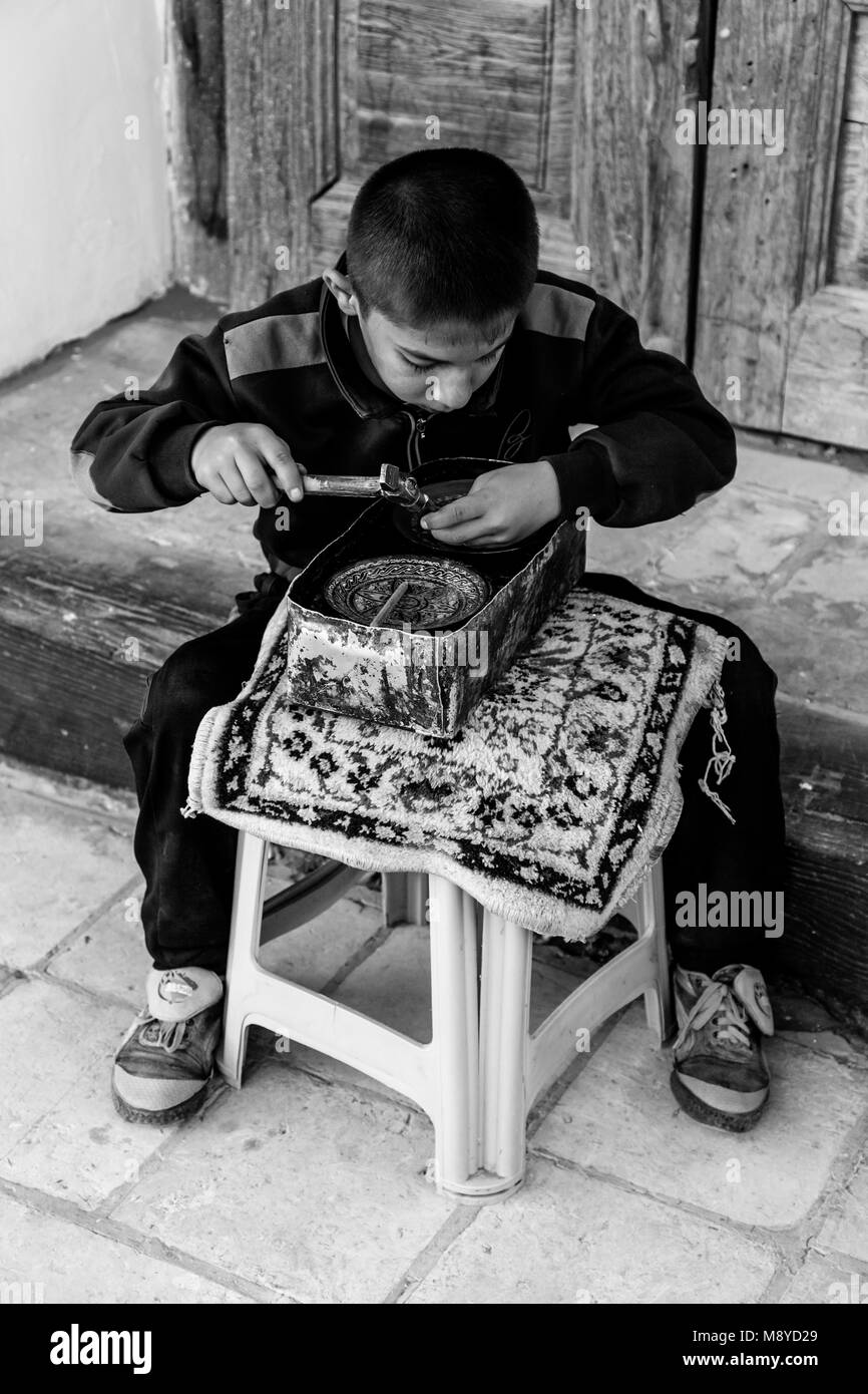 A Young Boy Engraving A Metal Plate At The Ark Fortress, Bukhara, Uzbekistan Stock Photo