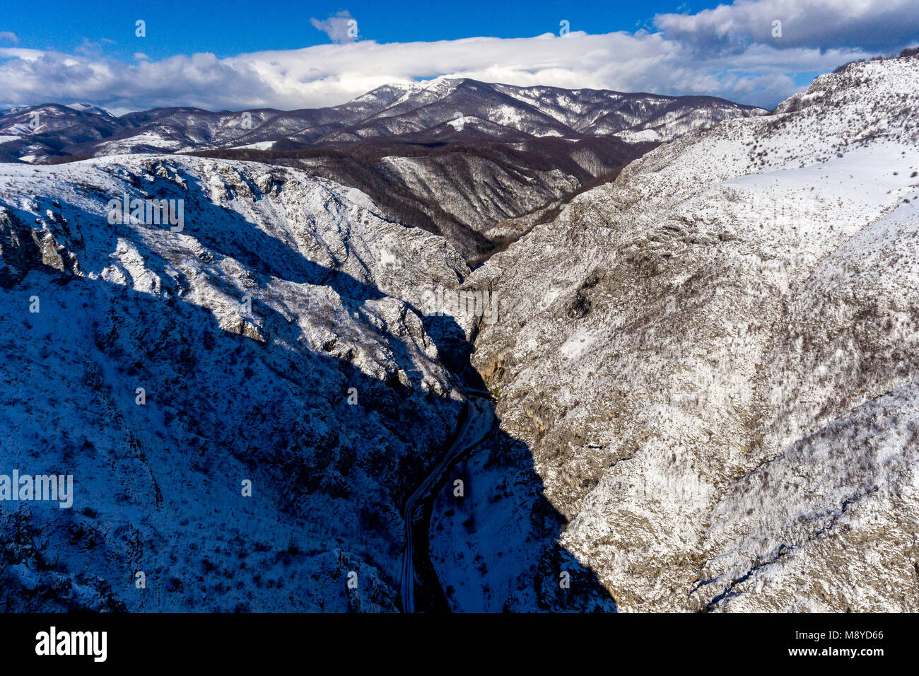 Winter mountain landscape with a snowy river valley shot from an aerial ...